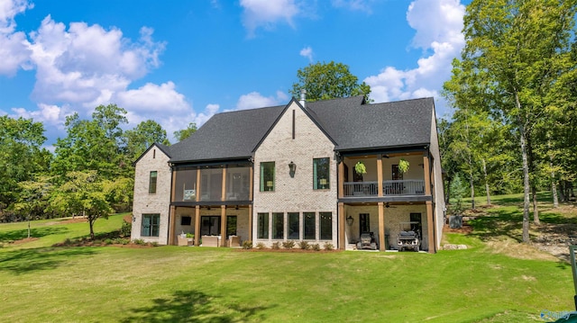 rear view of house featuring a sunroom, a lawn, a patio area, and a ceiling fan