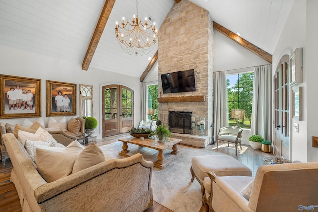 living room featuring a notable chandelier, a stone fireplace, beam ceiling, high vaulted ceiling, and hardwood / wood-style flooring