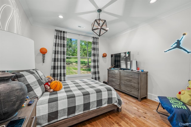 bedroom with light wood-style flooring, recessed lighting, baseboards, ornamental molding, and an inviting chandelier