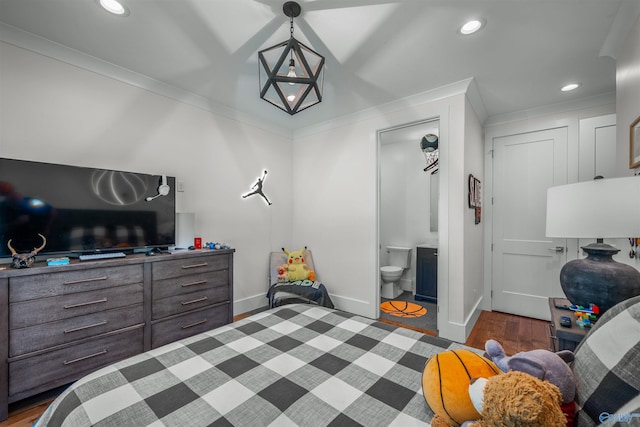 bedroom with ornamental molding, dark hardwood / wood-style flooring, and connected bathroom