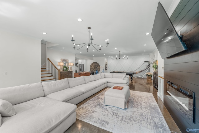 living room featuring an inviting chandelier and concrete floors