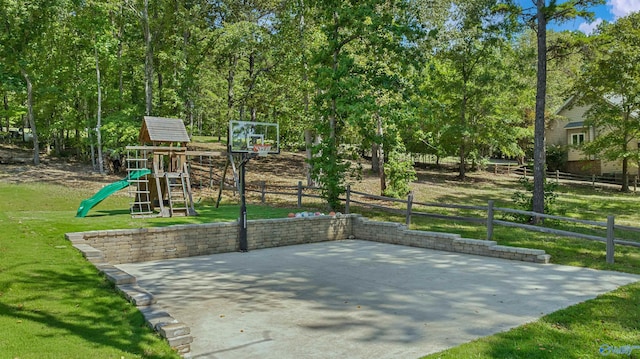 view of sport court featuring fence, basketball court, a playground, and a yard