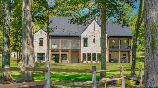 back of property featuring a lawn and a balcony