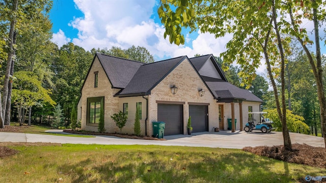view of front facade with concrete driveway, brick siding, a front lawn, and an attached garage