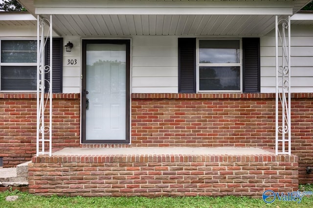 303 Bobwhite Dr SW, Decatur, AL 35601 - view of exterior entry featuring a porch and brick siding