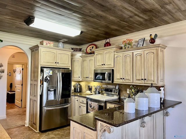 94 Owensby Way, Trinity, AL 35673 - kitchen with stainless steel appliances, a peninsula, arched walkways, light tile patterned floors, and dark stone countertops