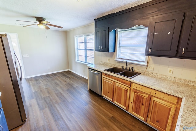 kitchen featuring dark wood-type flooring, stainless steel appliances, sink, and a textured ceiling