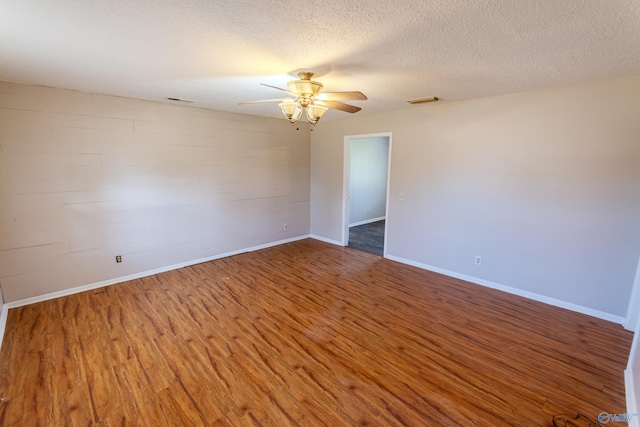 spare room featuring hardwood / wood-style flooring, ceiling fan, and a textured ceiling