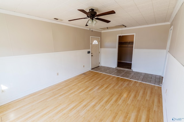 empty room featuring crown molding, hardwood / wood-style floors, and ceiling fan