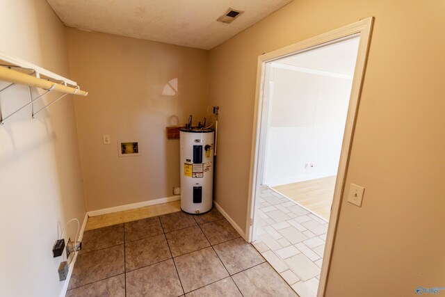 clothes washing area with washer hookup, light tile patterned floors, and water heater