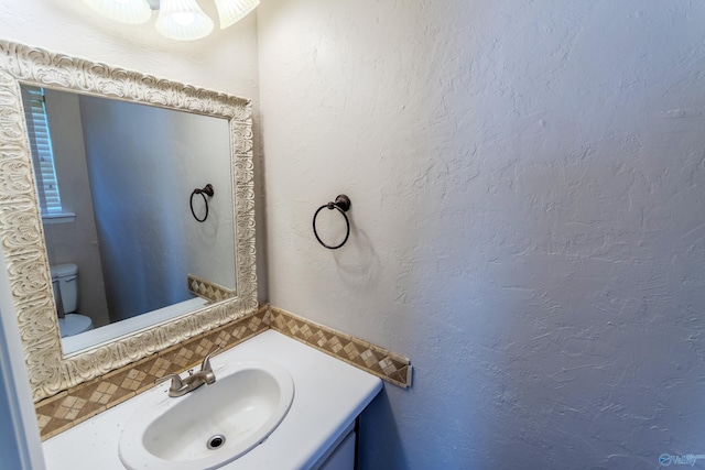 bathroom with tasteful backsplash, vanity, and toilet