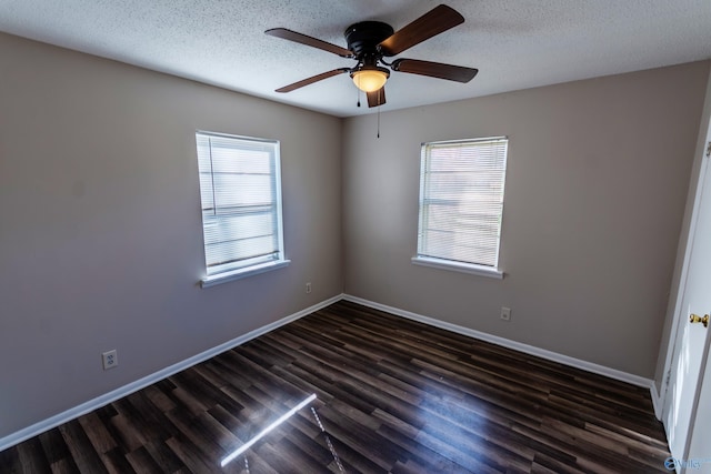 unfurnished room featuring ceiling fan, plenty of natural light, dark wood-type flooring, and a textured ceiling