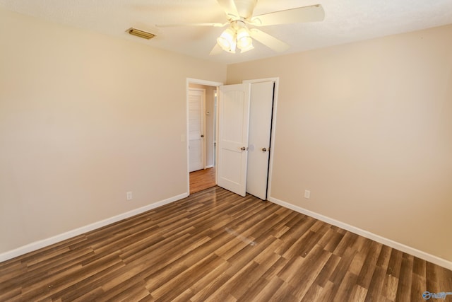 unfurnished room with dark wood-type flooring and ceiling fan