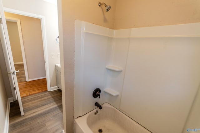 bathroom featuring hardwood / wood-style flooring, vanity, and bathtub / shower combination