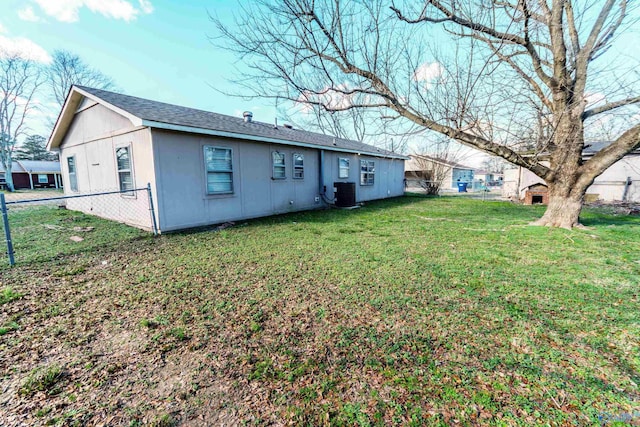 rear view of house featuring a yard and central AC