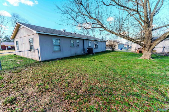 back of house featuring a yard and central AC