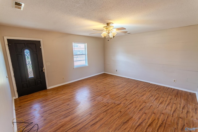 foyer with ceiling fan, wood-type flooring, and a textured ceiling