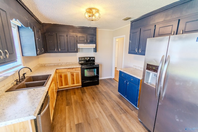 kitchen featuring sink, ornamental molding, stainless steel appliances, a textured ceiling, and light hardwood / wood-style flooring