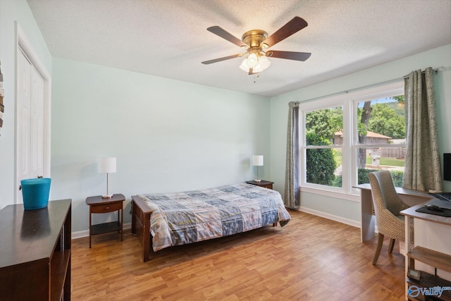 9410 Valley Ln, Huntsville, AL 35803 - bedroom featuring light wood-style floors, baseboards, an office area, a textured ceiling, and ceiling fan