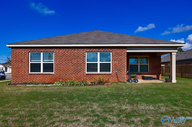 rear view of house with a yard and a patio