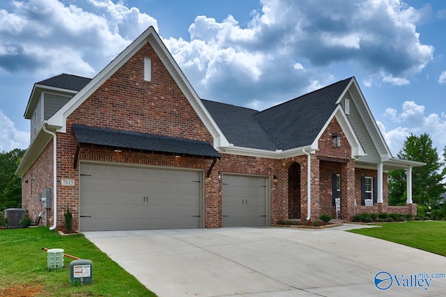 craftsman-style house featuring a garage, central air condition unit, and a front yard