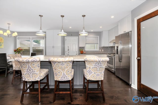 211 Kent Rd SW, Huntsville, AL 35801 - kitchen featuring stainless steel appliances, white cabinets, a sink, tasteful backsplash, and an island with sink