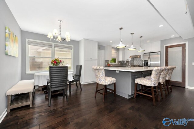 211 Kent Rd SW, Huntsville, AL 35801 - kitchen with stainless steel fridge with ice dispenser, light countertops, a chandelier, dark wood-style flooring, and decorative backsplash