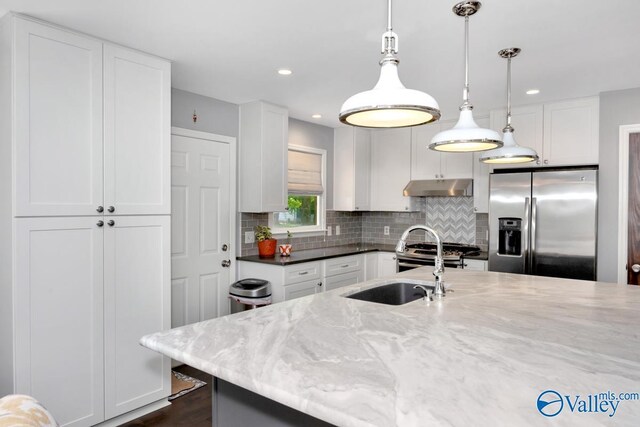 211 Kent Rd SW, Huntsville, AL 35801 - kitchen featuring stainless steel appliances, tasteful backsplash, white cabinets, under cabinet range hood, and light stone countertops