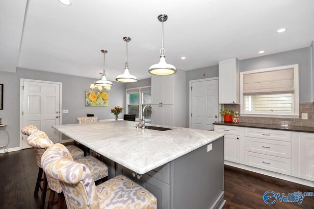 211 Kent Rd SW, Huntsville, AL 35801 - kitchen featuring a sink, white cabinets, a kitchen bar, dark wood-style floors, and recessed lighting