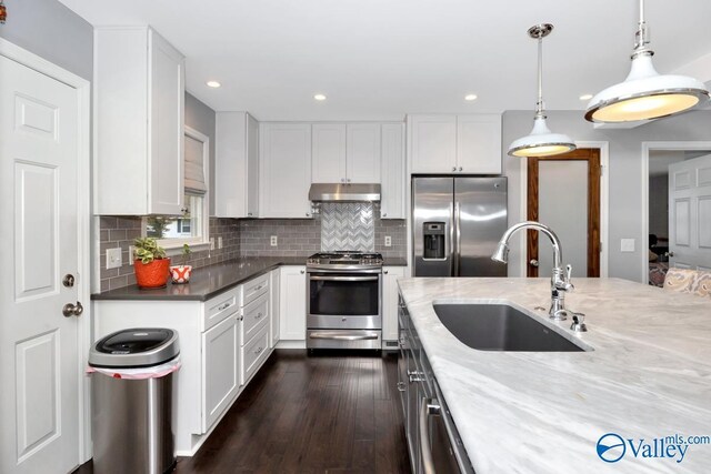 211 Kent Rd SW, Huntsville, AL 35801 - kitchen featuring under cabinet range hood, appliances with stainless steel finishes, a sink, dark wood-style flooring, and white cabinetry
