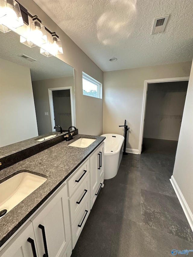 bathroom featuring visible vents, a sink, and baseboards