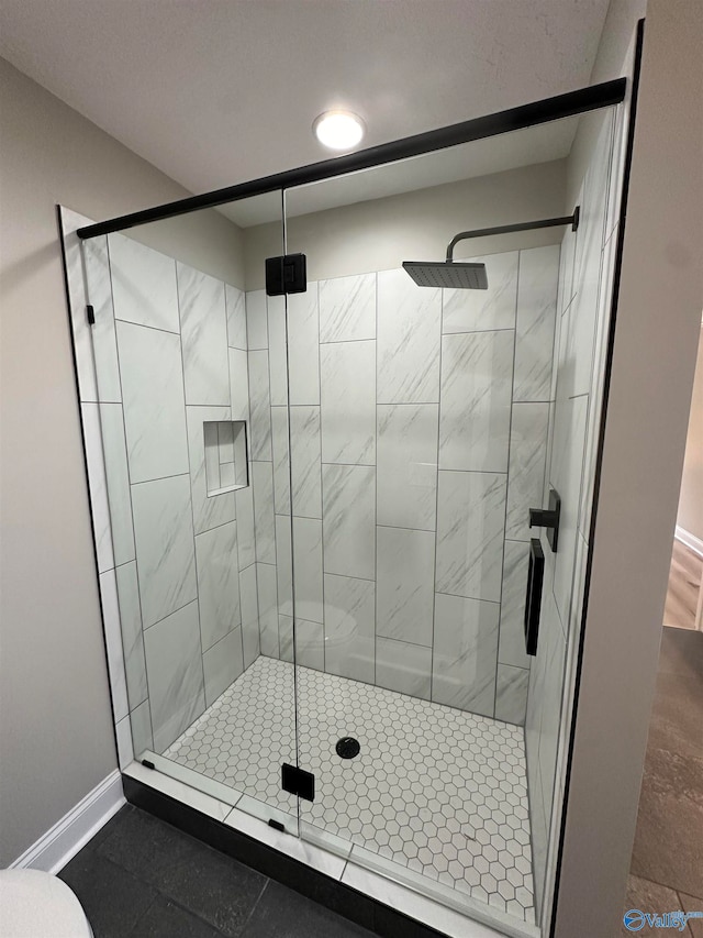 full bathroom featuring a stall shower and baseboards