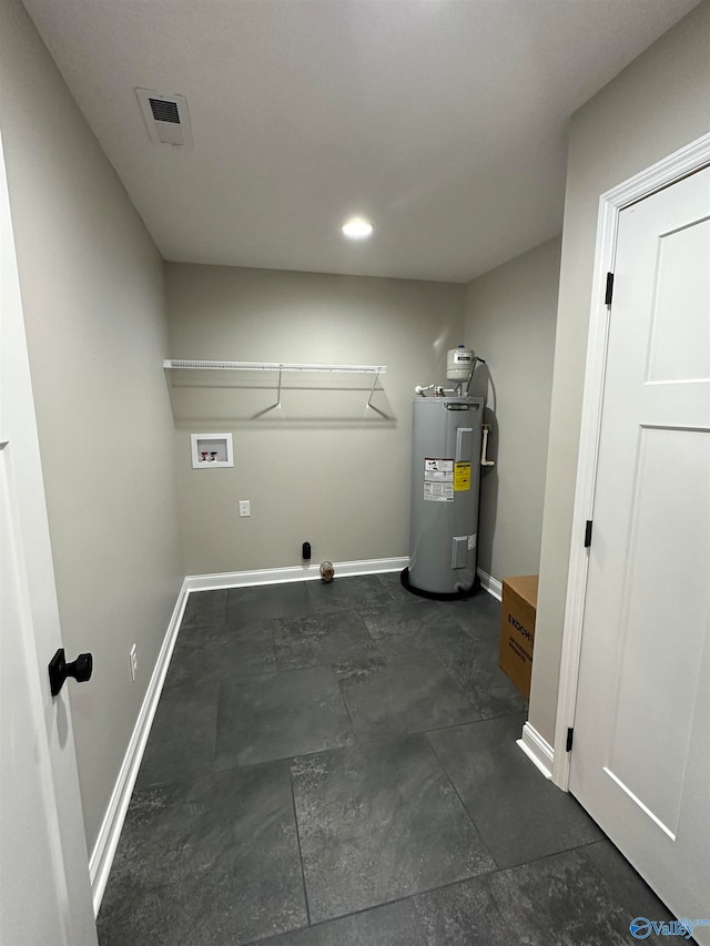 laundry room with laundry area, washer hookup, visible vents, baseboards, and water heater