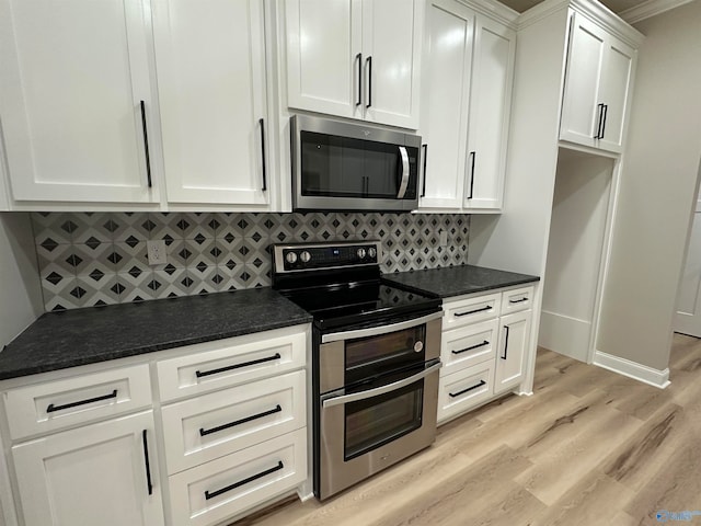 kitchen with white cabinets, light wood-style floors, stainless steel appliances, and backsplash