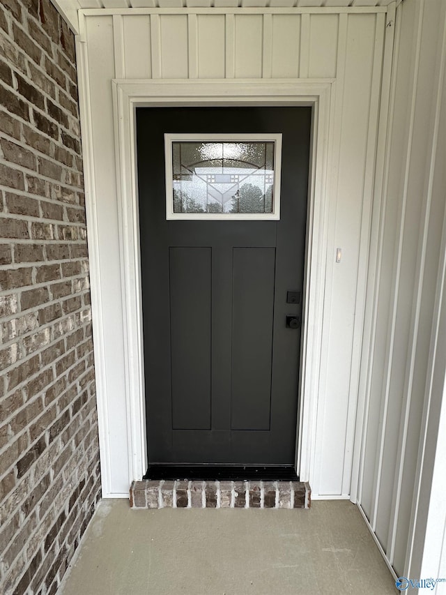 entrance to property featuring brick siding