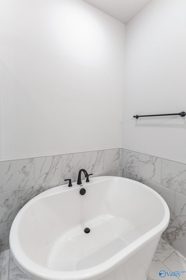 bathroom with a tub and tile patterned floors