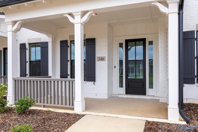 view of exterior entry featuring covered porch