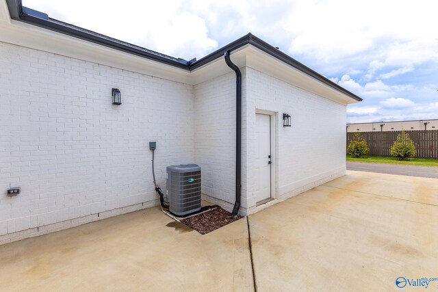 view of side of property featuring a patio and central AC