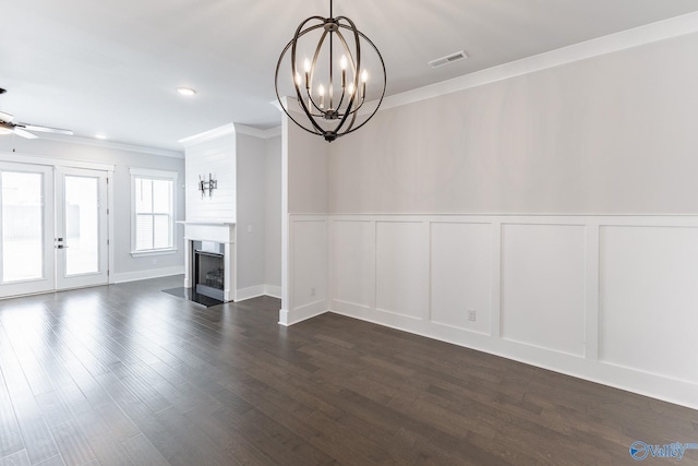 unfurnished living room featuring dark hardwood / wood-style floors, ceiling fan with notable chandelier, and ornamental molding