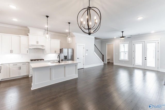 kitchen with gas cooktop, white cabinets, stainless steel fridge with ice dispenser, an island with sink, and dark hardwood / wood-style flooring