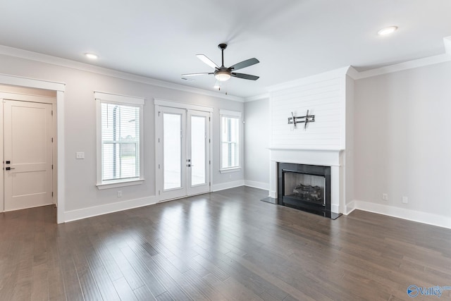 unfurnished living room with a large fireplace, a healthy amount of sunlight, ceiling fan, and dark hardwood / wood-style floors