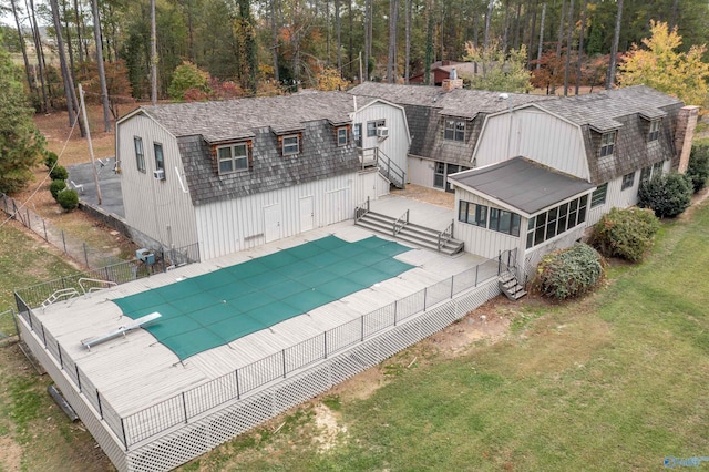 exterior space with a sunroom, a patio, a yard, and a covered pool