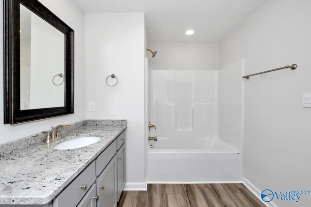 bathroom with shower / bathtub combination, vanity, and hardwood / wood-style floors