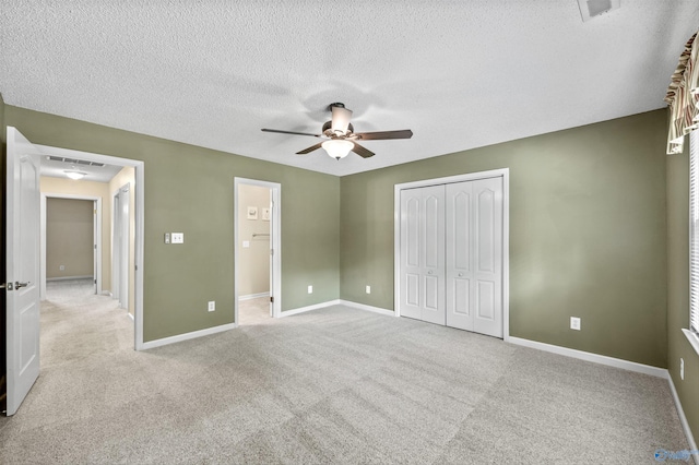 221 Badger Dr, Harvest, AL 35749 - unfurnished bedroom featuring a textured ceiling, a closet, light colored carpet, baseboards, and a ceiling fan