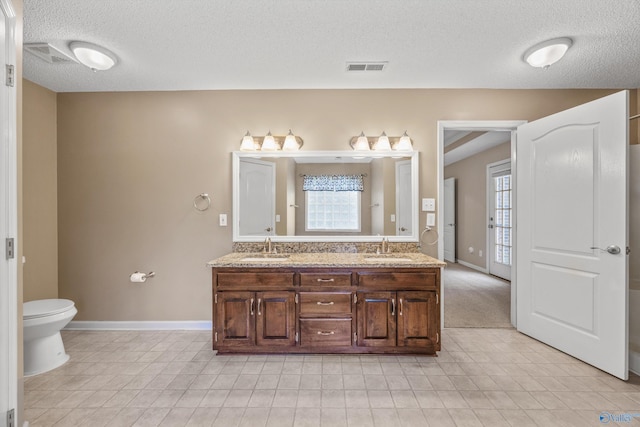 221 Badger Dr, Harvest, AL 35749 - full bath featuring double vanity, healthy amount of natural light, a textured ceiling, toilet, and baseboards
