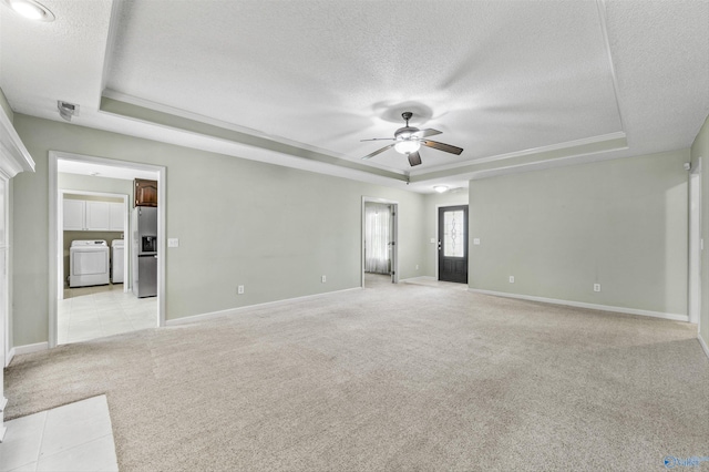 221 Badger Dr, Harvest, AL 35749 - unfurnished room with a tray ceiling, a textured ceiling, washer and dryer, a ceiling fan, and light colored carpet