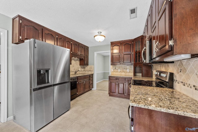 221 Badger Dr, Harvest, AL 35749 - kitchen featuring stainless steel appliances, tasteful backsplash, a sink, light stone countertops, and a textured ceiling
