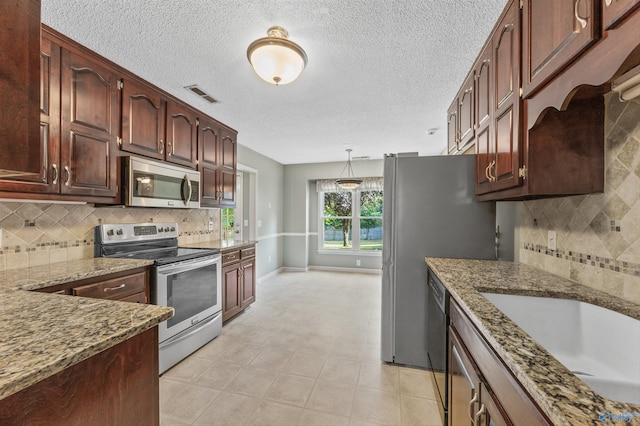221 Badger Dr, Harvest, AL 35749 - kitchen with stainless steel appliances, stone counters, baseboards, decorative backsplash, and decorative light fixtures