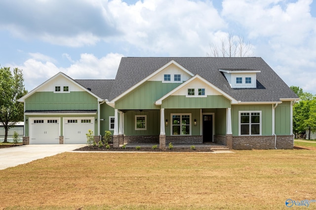 craftsman-style home with covered porch, a garage, and a front lawn