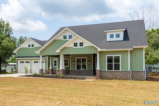 craftsman house with a porch, a garage, and a front yard